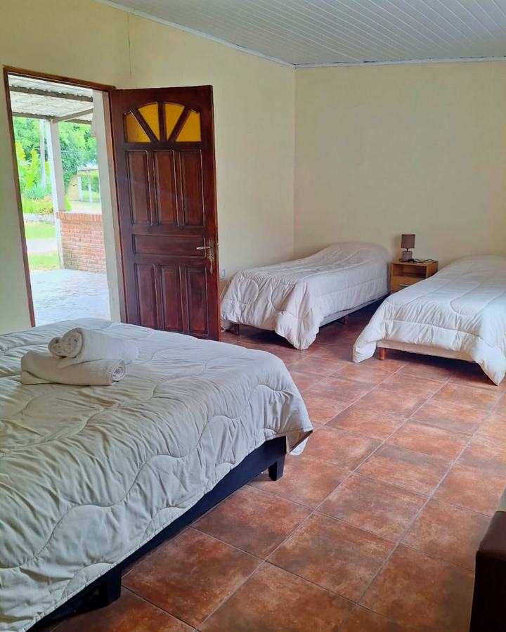 Habitación cuádruple con puerta de madera abierta hacia el jardín