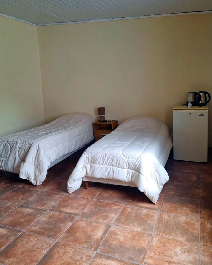 Dos camas single, mesa de luz y frigobar