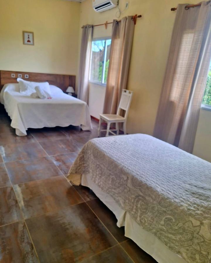 Habitación triple con cama matrimonial, cama single y ventanales